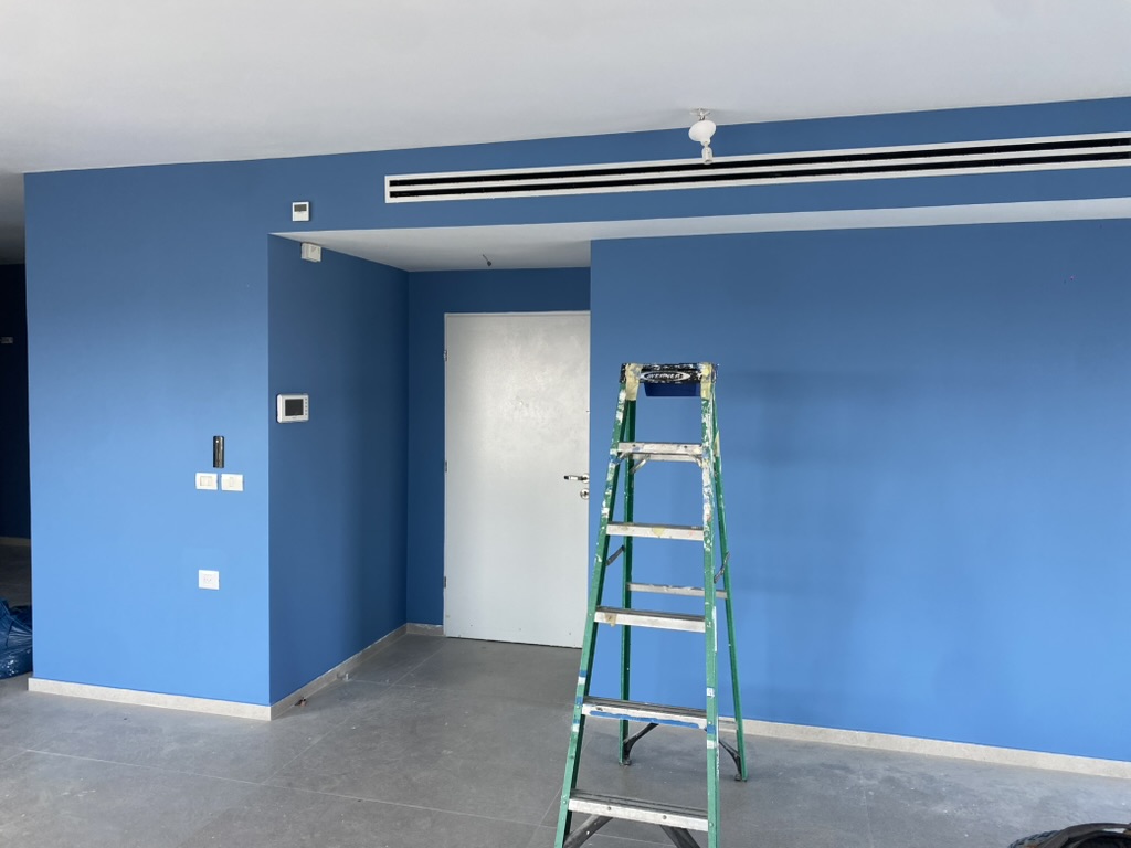 Fresh blue paint across a living room wall