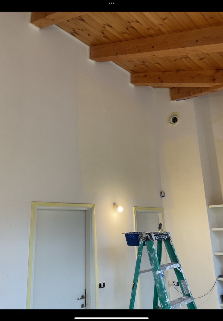 Tall interior with wood beams prepared for painting